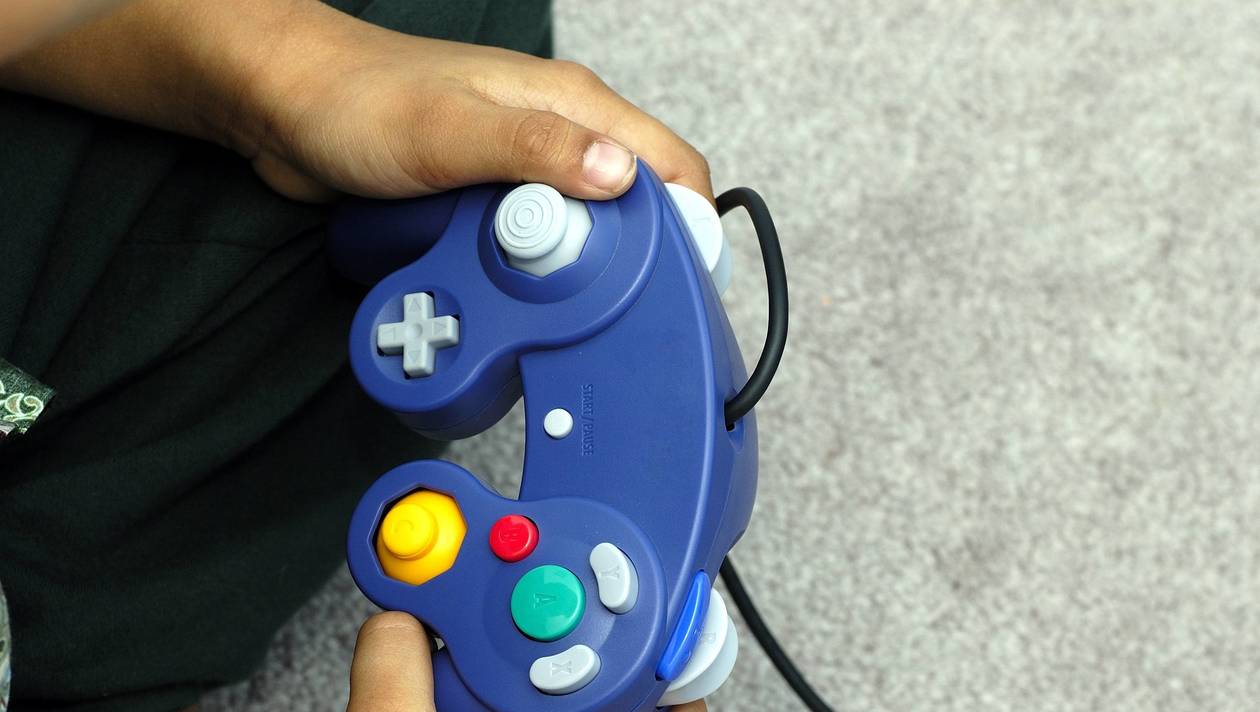 Un enfant joue à un jeu vidéo sur une console de jeu GameCube de Nintendo